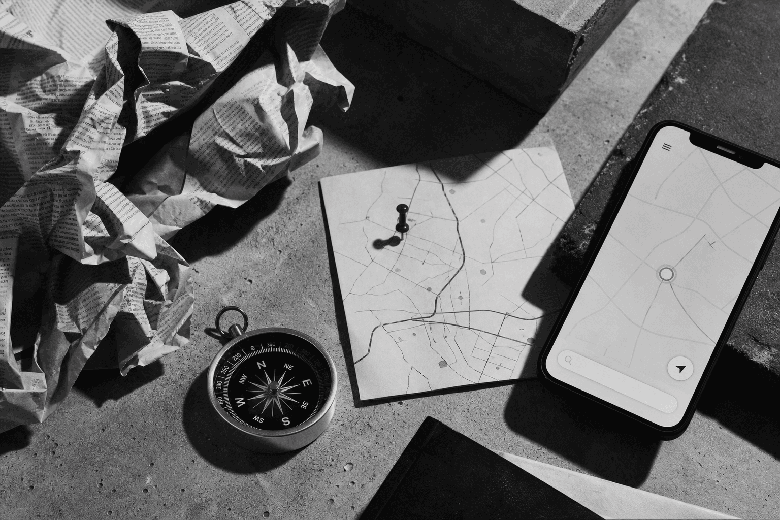 Map, compass, and phone arranged for local search work